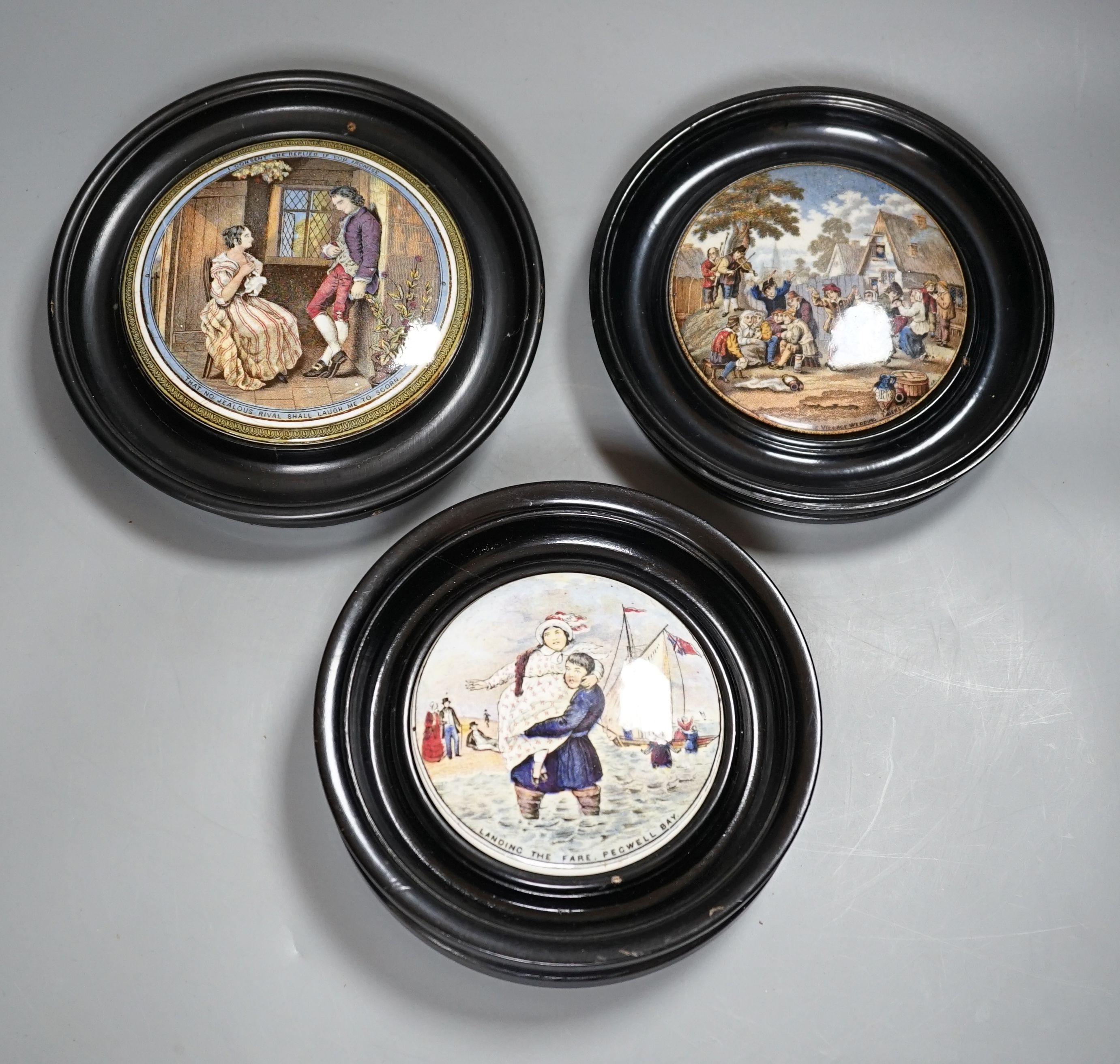 Seven Prattware pot lids, mounted in ebonised wood frames, an F & R Pratt plate and two pot lids with bases